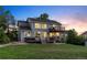 Well-lit backyard featuring a two-level deck, spacious lawn, and inviting landscape at dusk at 10039 Heatherwood Pl, Highlands Ranch, CO 80126