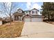 Charming two-story home featuring a brick and gray exterior, a well-maintained lawn, and an attached two-car garage at 10039 Heatherwood Pl, Highlands Ranch, CO 80126