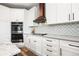 Well-appointed kitchen with white cabinetry, stainless steel appliances, and a stylish backsplash at 10039 Heatherwood Pl, Highlands Ranch, CO 80126