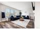 Spacious living room with a large blue sectional sofa, decorative rug, and natural light from big window at 10039 Heatherwood Pl, Highlands Ranch, CO 80126
