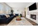 Inviting living room features a plush blue sectional sofa, cozy fireplace, and stylish decor accents at 10039 Heatherwood Pl, Highlands Ranch, CO 80126