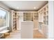 Spacious walk-in closet featuring custom shelving, drawers, and ample storage space at 10039 Heatherwood Pl, Highlands Ranch, CO 80126