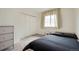 Cozy bedroom with dark bedding, wooden bedside table, and large window offering natural light at 1117 Elysian Field Dr # A, Lafayette, CO 80026