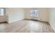 A well-lit room with light gray wood floors and a large window looking out onto the neighborhood at 1117 Elysian Field Dr # A, Lafayette, CO 80026