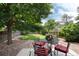 Serene backyard features lush greenery, a shaded patio, and outdoor seating, ideal for relaxation at 8543 Redstone St, Highlands Ranch, CO 80126