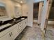 Modern bathroom showcasing dual sinks, granite countertops and a shower with glass door at 8543 Redstone St, Highlands Ranch, CO 80126