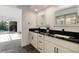 Bathroom featuring double sinks, dark fixtures, and a view of the outdoor space at 8543 Redstone St, Highlands Ranch, CO 80126
