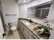 Bathroom with granite countertop, modern fixtures, and a shower with glass door at 8543 Redstone St, Highlands Ranch, CO 80126