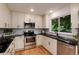 Updated kitchen boasts black countertops, white cabinets, and stainless steel appliances at 8543 Redstone St, Highlands Ranch, CO 80126
