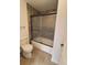 Modern shower features glass doors, neutral stone tile, and tiled floors at 8543 Redstone St, Highlands Ranch, CO 80126