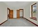 Carpeted bedroom with wooden doors and trim and large windows at 2411 N High St, Denver, CO 80205