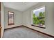 Cozy bedroom with neutral paint, carpet, wood trim, and tree views at 2411 N High St, Denver, CO 80205