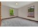 Bright bedroom featuring plush carpet, two windows, and neutral paint at 2411 N High St, Denver, CO 80205