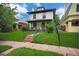 Beautiful two-story home with a covered porch, green lawn and mature landscaping at 2411 N High St, Denver, CO 80205