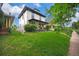 A well-manicured front yard frames this lovely two-story home with a quaint porch at 2411 N High St, Denver, CO 80205