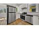 Updated kitchen featuring white cabinets, stainless appliances, and a large refrigerator at 2411 N High St, Denver, CO 80205