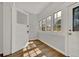 Bright sun room with wood-look floors features three windows and glass doors at 2411 N High St, Denver, CO 80205