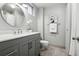 Modern bathroom features a gray vanity with a marble countertop, a round mirror, and decorative artwork at 930 Acoma St # 108, Denver, CO 80204