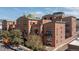 View of a brick apartment building with multiple floors, patios, and views of the city at 930 Acoma St # 108, Denver, CO 80204