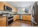 Functional kitchen featuring granite counters, wood cabinetry, and stainless steel appliances at 930 Acoma St # 108, Denver, CO 80204