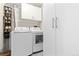 Well-organized laundry area with a washer, dryer, storage cabinets, and a shelving unit for shoes at 930 Acoma St # 108, Denver, CO 80204