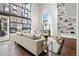 Bright living room featuring hardwood floors, large windows, and custom built-in shelving at 930 Acoma St # 108, Denver, CO 80204