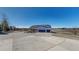 View of the exterior with a three car garage, blue siding, stone accents, and a spacious driveway at 14701 Yosemite St, Brighton, CO 80602