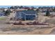 Elevated view of home with a two-story deck and patio area, surrounded by mature trees at 14701 Yosemite St, Brighton, CO 80602