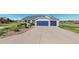 Home exterior with a two-car garage, well-maintained lawn, and garden, set back from a long driveway at 14701 Yosemite St, Brighton, CO 80602