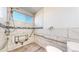 Bathroom shower with tile surround, window, folding seat and safety grab bars at 14701 Yosemite St, Brighton, CO 80602
