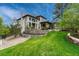 Stunning backyard featuring a patio, stone retaining wall, and a sprawling green lawn at 5428 Forest View Rd, Parker, CO 80134