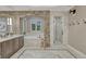 Gorgeous bathroom featuring stone archway over tub, double vanity, and glass enclosed shower with stone accent wall at 5428 Forest View Rd, Parker, CO 80134