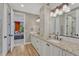 Bathroom featuring double vanity, wood flooring, granite countertops, and entry to bedroom at 5428 Forest View Rd, Parker, CO 80134