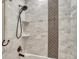 Bathroom featuring decorative tiling in the shower and a rainfall shower head at 5428 Forest View Rd, Parker, CO 80134