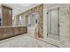 Gorgeous bathroom featuring stone archway over tub, double vanity, and glass enclosed shower with stone accent wall at 5428 Forest View Rd, Parker, CO 80134