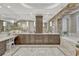 The bright bathroom features a stone archway over the tub, double vanity with marble countertop, and tiled floors at 5428 Forest View Rd, Parker, CO 80134