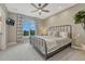 This bedroom features a dark metal frame bed, a large window with patterned curtains, and neutral carpet at 5428 Forest View Rd, Parker, CO 80134