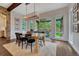 Bright dining room with wood floors and large windows offering backyard views, stone accents, and modern lighting at 5428 Forest View Rd, Parker, CO 80134