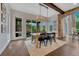 Open dining room with lots of natural light, wood floors, stone accents, and modern light fixtures at 5428 Forest View Rd, Parker, CO 80134