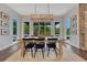 Bright dining room with natural light, wood floors, a stone accent wall, and a modern light fixture at 5428 Forest View Rd, Parker, CO 80134