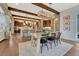 Open-concept dining room with wood floors, stone accents, modern lighting, and a glimpse into the kitchen at 5428 Forest View Rd, Parker, CO 80134