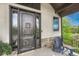 Close-up of custom front door with decorative sidelights and a small outdoor seating area at 5428 Forest View Rd, Parker, CO 80134