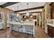 Kitchen with large island, stone archway and dark cabinets at 5428 Forest View Rd, Parker, CO 80134
