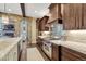 Modern kitchen with dark wood cabinets, stainless steel appliances, and a gas range at 5428 Forest View Rd, Parker, CO 80134