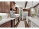 Well-appointed kitchen with stainless steel appliances, dark wood cabinets, a tile backsplash, and stone countertops at 5428 Forest View Rd, Parker, CO 80134