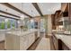 Open kitchen featuring an island with stone countertops, stainless steel appliances, and stone accent arches at 5428 Forest View Rd, Parker, CO 80134