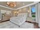 Bright main bedroom featuring a large bed, patterned rug, dark wood floors, and a large decorative light fixture at 5428 Forest View Rd, Parker, CO 80134
