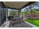 Covered patio with a dining table, grill, stone pillars, and views of the landscaped backyard at 5428 Forest View Rd, Parker, CO 80134
