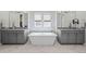 A luxurious bathroom featuring dual sinks and a soaking tub, complemented by modern fixtures and decor at 8172 S Langdale Way, Aurora, CO 80016