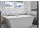 Close-up on a soaking tub, showcasing modern fixtures, bright natural light, and clean design elements at 8172 S Langdale Way, Aurora, CO 80016